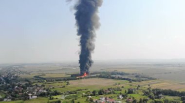 Quadcopter'dan Büyük ateş manzarasının havadan görünümü. Siyah duman gökyüzüne yükselir. Şehrin eteklerinde yangın