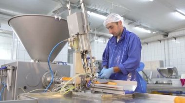 Sosis üretim hattı. Çalışan üretim hattında sosis yapar, yarı otomatik yöntemle doldurur, keser ve bağlar