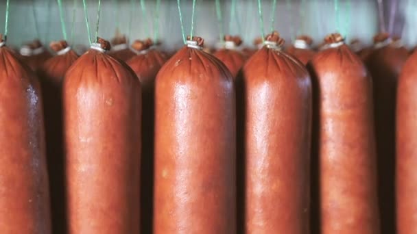 Saucisse qui est suspendu sur les étagères, sèche dans la salle de stockage. Panorama de la saucisse suspendue aux lacets du réfrigérateur . — Video