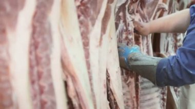 İşçi domuz daha deboning için bir domuz karkas et parçaları keser
