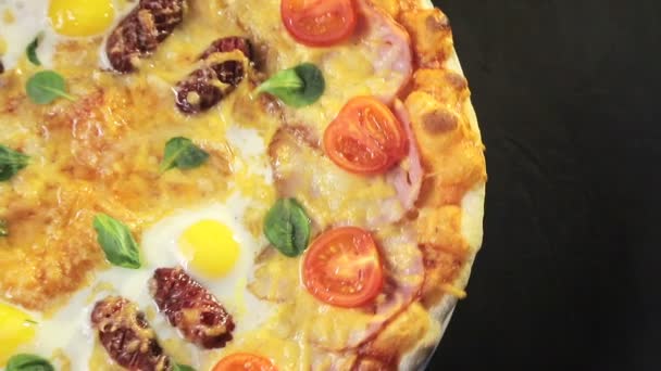 Вид зверху смачна піца, яка обертається натал крупним планом. Піца з сосискою, помідорами та грибами . — стокове відео