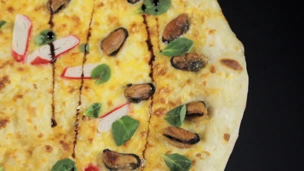 Pizza con bastoncini di granchio su sfondo nero vista dall'alto — Video Stock