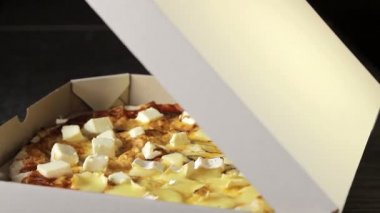 Paketin içinde kendi etrafında dönen dört peynirin orijinal planının pizzası..