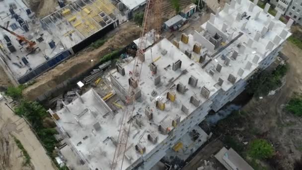 Вид з повітря на будівельний майданчик, і будівельний кран зверху. Панорама будівлі — стокове відео
