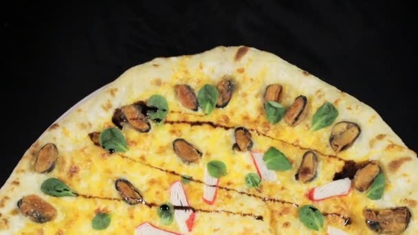 Pizza con palitos de cangrejo en una vista de fondo negro desde la parte superior — Vídeos de Stock