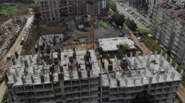 Tamamlanmamış monolitik eve yakın bir uçuş. İnşaat vinci inşaat alanının yanında. İnşaatın üst görüntüsü
