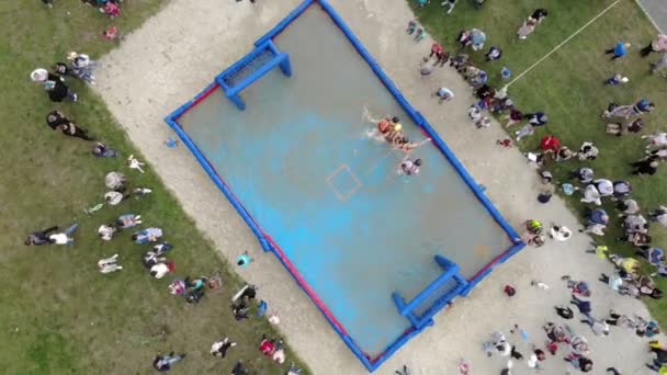 Luftaufnahme beim Fußballspielen in einem aufblasbaren Pool, der mit Wasser gefüllt ist. Fußball im Wasser. — Stockvideo