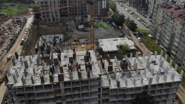 Flucht in der Nähe des unfertigen monolithischen Hauses. Baukran in der Nähe der Baustelle. Blick von oben auf die Konstruktion — Stockvideo