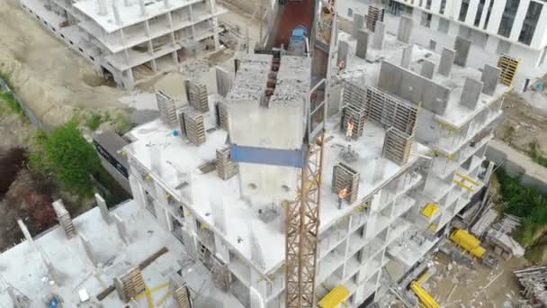 Flucht in der Nähe des unfertigen monolithischen Hauses. Baukran in der Nähe der Baustelle. Blick von oben auf die Konstruktion — Stockvideo