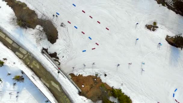 Flygfoto från toppen, idrottare skidåkare övervinna avstånd på skidor som passerar genom postat rutt från Kina och röda marker. — Stockvideo