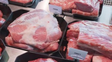 İştah açıcı et ürünleri özel kaplarda sergileniyor. Süpermarket vitrininde satılık et ürünleri.