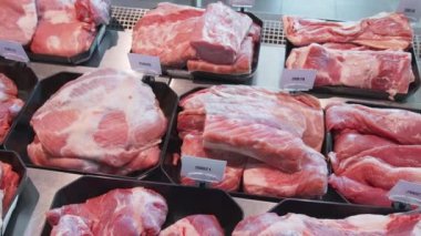 İştah açıcı et ürünleri özel kaplarda sergileniyor. Süpermarket vitrininde satılık et ürünleri.