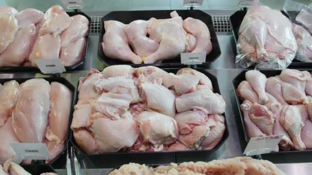 Appetizing chicken semi-finished products are on display in special containers. Chicken products for sale in a supermarket window. — Stock Video