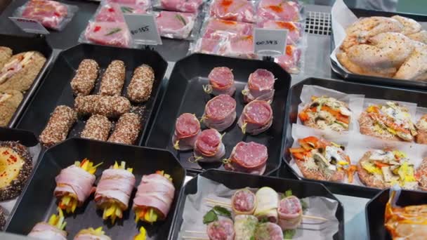 Apetyczne produkty mięsne są na wystawie w specjalnych pojemnikach. Produkty mięsne na sprzedaż w oknie supermarketu. — Wideo stockowe