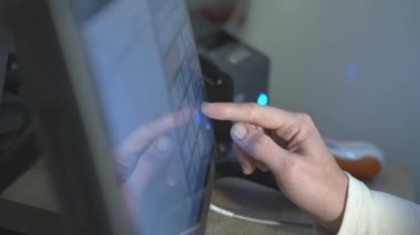 Koruyucu eldivenli süpermarket çalışanlarının kapatılması bilgisayar ekranına parmak basıyor. Süpermarkette satın alma maliyetinin hesaplanması