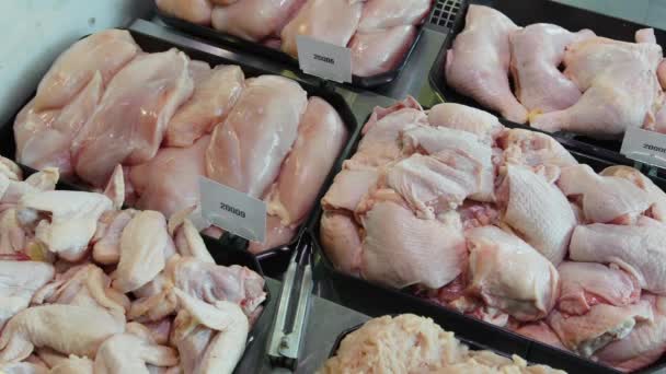 Los apetecibles productos semielaborados de pollo se exhiben en recipientes especiales. Productos de pollo a la venta en una ventana de supermercado . — Vídeo de stock