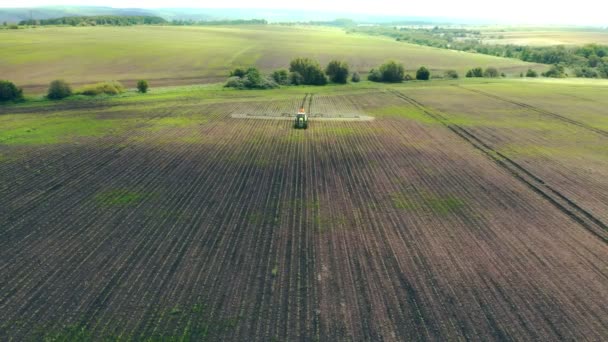 Vue aérienne Machines agricoles pulvérisant de l'insecticide sur le champ vert, travaux agricoles naturels saisonniers de printemps. Tracteur agricole pulvérisation sur le terrain avec pulvérisateur — Video