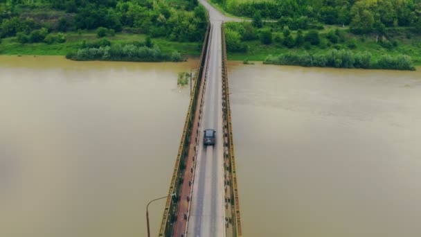 Ponte de emergência que passa por um carro. O carro se move através da ponte sobre um rio lotado durante inundações . — Vídeo de Stock