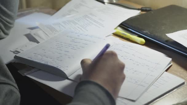 El hombre resuelve problemas matemáticos en un cuaderno y se prepara para el entrenamiento. El hombre escribe con una fórmula de pluma en un cuaderno de cerca . — Vídeo de stock