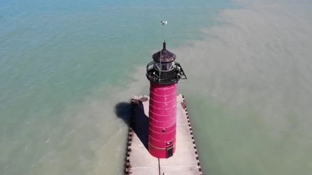 Red lighthouse by the sea on a sunny day. View from a quadcopter on a red lighthouse. — Stock Video