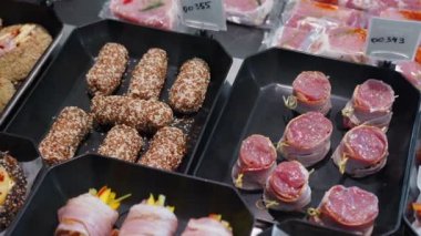 İştah açıcı et ürünleri özel kaplarda sergileniyor. Süpermarket vitrininde satılık et ürünleri.