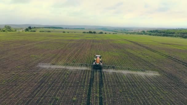 Letecký výhled Zemědělské stroje rozprašující insekticid na zelené pole, zemědělské přírodní sezónní jarní práce. Farming tractor spraying on field with sprayer — Stock video