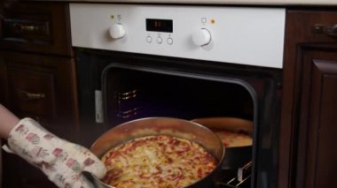 Sosisli ve domatesli taze pişmiş pizza fırından çıkartılır..