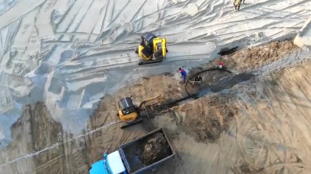 Vista aérea Máquinas em um canteiro de obras. Trabalhos de construção com a ajuda de tractores e outros equipamentos de construção — Vídeo de Stock