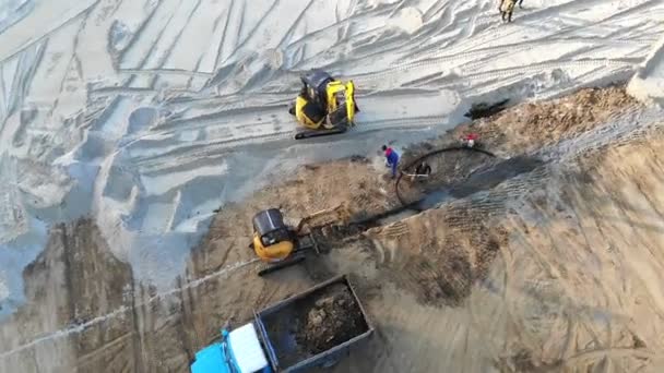 Vista aérea Máquinas em um canteiro de obras. Trabalhos de construção com a ajuda de tractores e outros equipamentos de construção — Vídeo de Stock