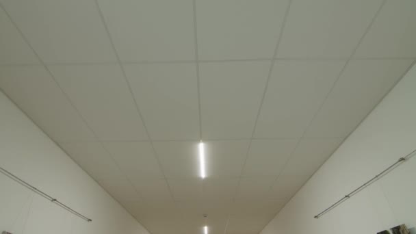 Movimiento de la cámara y mirar hacia arriba, techo blanco con iluminación. POV — Vídeos de Stock