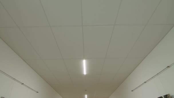 Movimento della fotocamera e guardare in alto, soffitto bianco con illuminazione. Luogo di nascita: — Video Stock