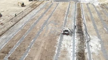 Bir inşaat sahasında havadan izleme cihazı. Traktörlerin ve diğer inşaat ekipmanlarının yardımıyla inşaat işi