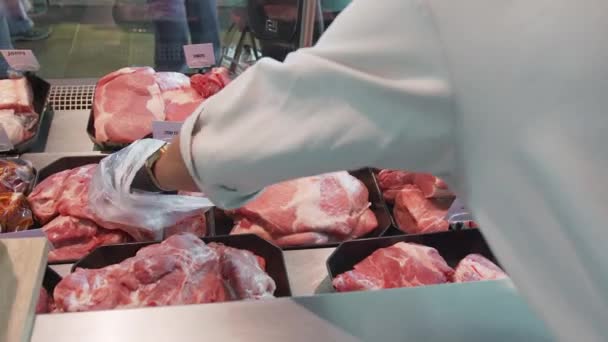 Vendedor elige un pedazo de carne en un escaparate de cerca — Vídeos de Stock