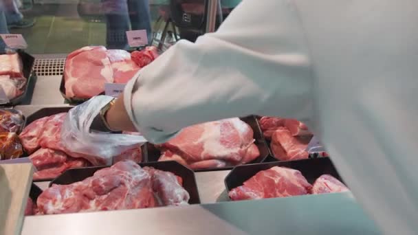 Prodávající si vybere kus masa v uzavřeném okně obchodu
