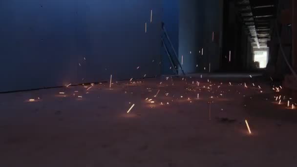 Sparks from welding that fall to the ground in slow motion on a construction site. — Stock video