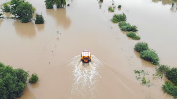 Ukrajina. Galych 24. června2020. Letecký pohled na ambulanci pokračuje po zatopené silnici města, která byla zaplavena povodněmi řeky. Záchranáři jdou zachraňovat lidi v zatopených domech — Stock video