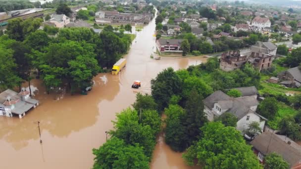 Ukrayna. Galych 24 Haziran 2020. Nehir taşkınları yüzünden sel basmış olan şehrin su basmış yoluna ambulansın hava görüntüsü veriliyor. Kurtarma ekipleri su basmış evlerde insanları kurtarmaya gidiyor. — Stok video