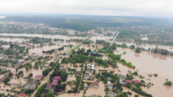 Milieuramp en klimaatverandering. Luchtfoto rivier die de stad en huizen overstroomde. Overstroomde huizen in het water. — Stockvideo