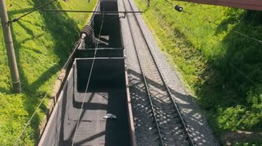 Yük treni boş arabalarla seyahat ediyor. Hareket halindeki bir trenin boş vagonlarının en üst görüntüsü.