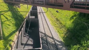 Yük treni boş arabalarla seyahat ediyor. Hareket halindeki bir trenin boş vagonlarının en üst görüntüsü.