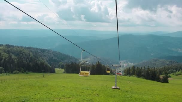 Güneşli bir yaz gününde, dağların panoramasında, teleferiğin sandalyesinden manzarayı izleyin. Güzel Karpat dağları ve teleferik dağın tepesine yükseliyor.. — Stok video