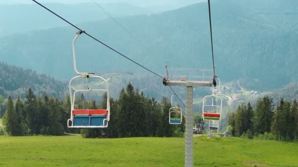 Vue depuis la chaise du téléphérique sur le panorama des montagnes par une journée ensoleillée d'été. Magnifiques montagnes des Carpates et téléphérique jusqu'à la montagne High Top. — Video
