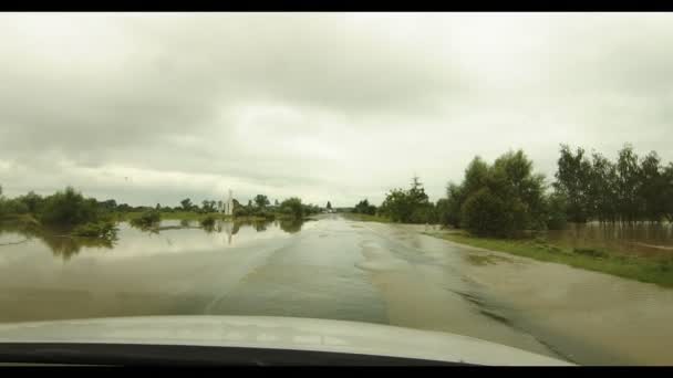 Pohled z okna auta jedoucího po zatopené silnici. Kamera se třese z nerovnosti silnice. Zaplavená dálnice POV — Stock video