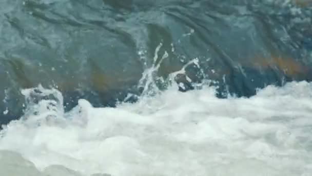 Nahaufnahme des in einem stürmischen Fluss fließenden Wassers. Blaues Wasser fließt heftig in einen Gebirgsfluss. — Stockvideo