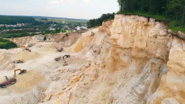 Excavator working in a sand quarry and extracting sand. An excavator picks up sand with a bucket and dumps it at the bottom of the quarry. — Stock Video