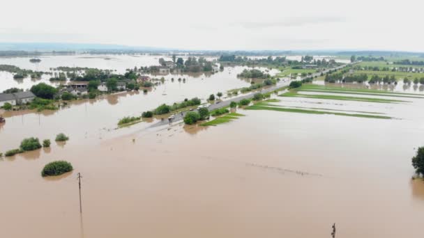 Вид с воздуха на реку, которая переполнена после сильных дождей и затопленных сельскохозяйственных полей — стоковое видео