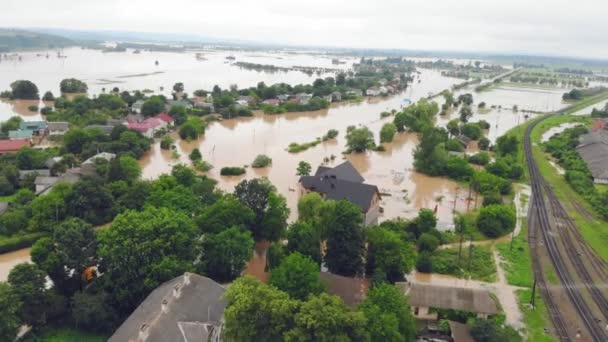 Vista aérea desde arriba sobre las casas inundadas y la ciudad. Inundación tras inundación de las montañas. Las casas están inundadas con agua sucia del río inundado — Vídeo de stock