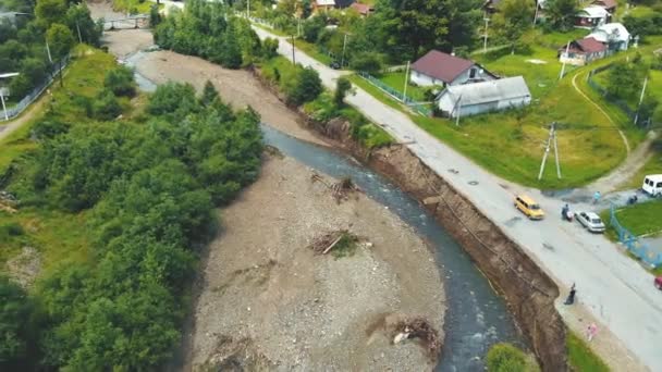 Vista aerea strada nel villaggio che è stato distrutto da un'alluvione sul fiume. La strada asfaltata che è stata tolta lavando dal fiume di montagna è distrutta. — Video Stock