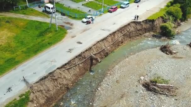 Luchtzichtweg in het dorp die werd verwoest door een overstroming op de rivier. De asfaltweg die door de bergrivier werd weggespoeld wordt vernietigd. — Stockvideo