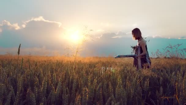 Femme artiste qui peint un tableau des épis de blé au coucher du soleil. L'artiste peint un tableau avec des épis de blé avec de la peinture. Les rayons du soleil brillent dans la caméra. — Video